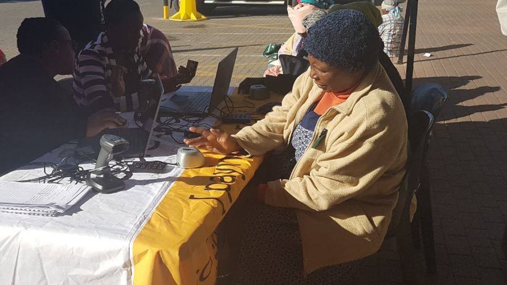 Old Age beneficiary completing ID verification and biometric fingerprint scan at a local SASSA office, SASSA ID Verification for June 2025 Grant Payments